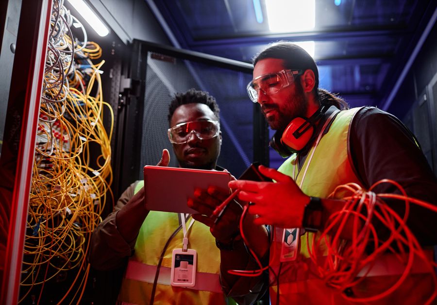 Technicians tracing cables in a server rack